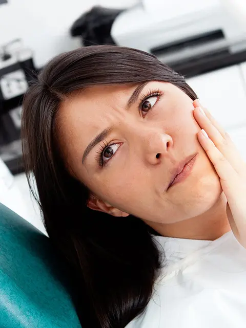 Woman experiencing orthodontic discomfort and poking wire.