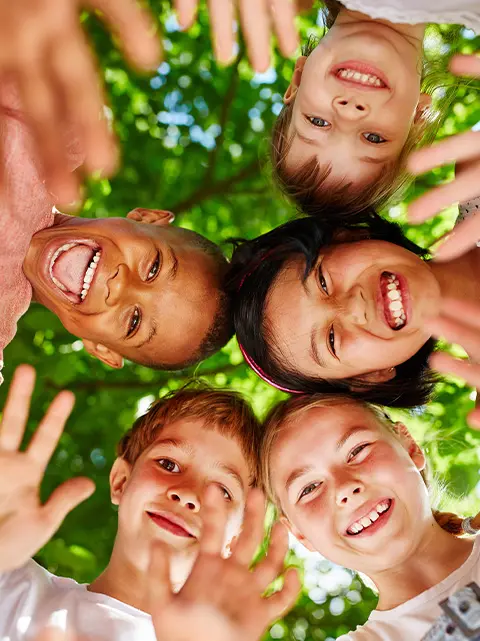 Smiling children's faces and hands, representing a family-friendly orthodontic environment in Akron, OH.